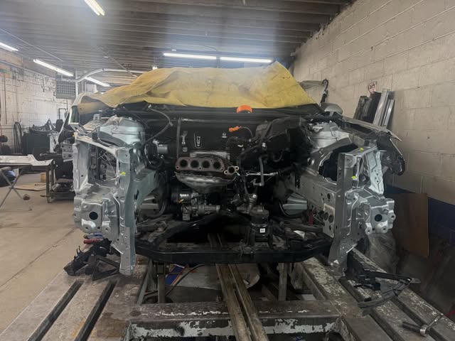 Car stripped down on the frame straightening bench
